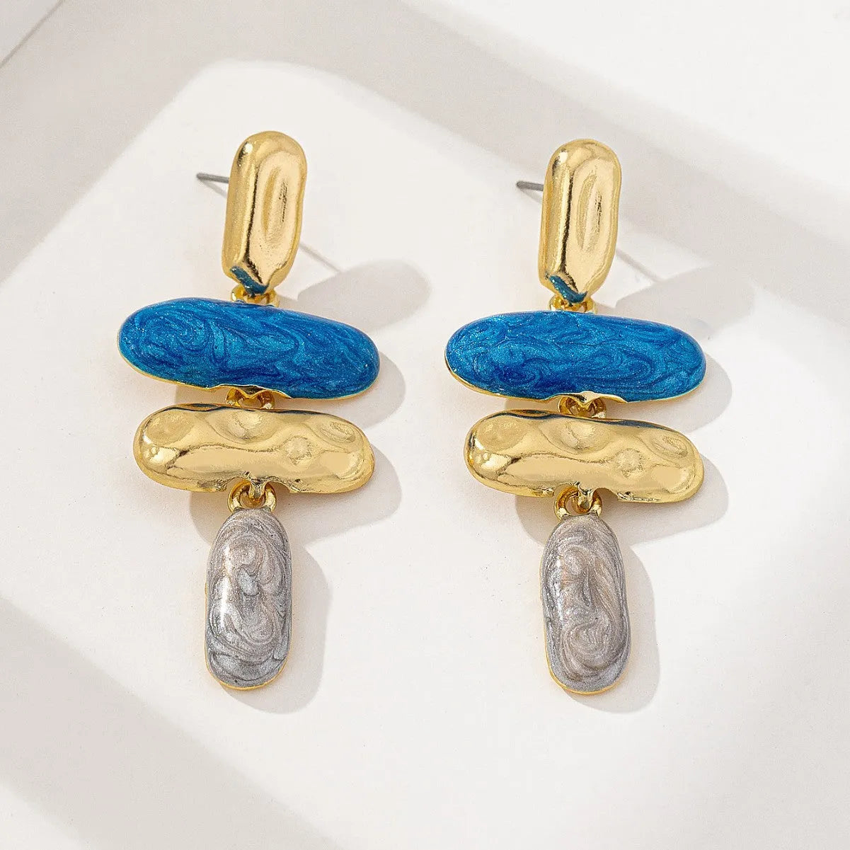 A pair of simple geometric stud earrings with a multicolour metallic finish.
