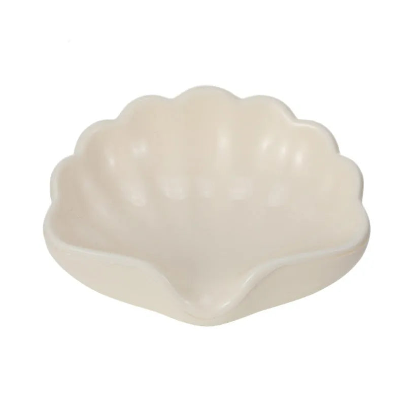 White or pink shell-shaped plastic soap dish for bathroom countertop.