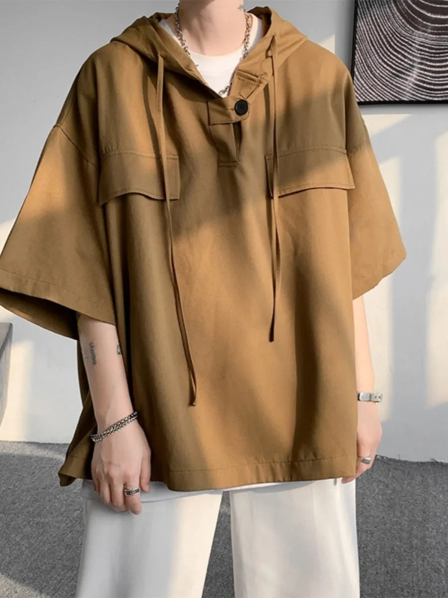 Man modelling a loose grey hooded short sleeve t-shirt, showing the pullover style and front design.