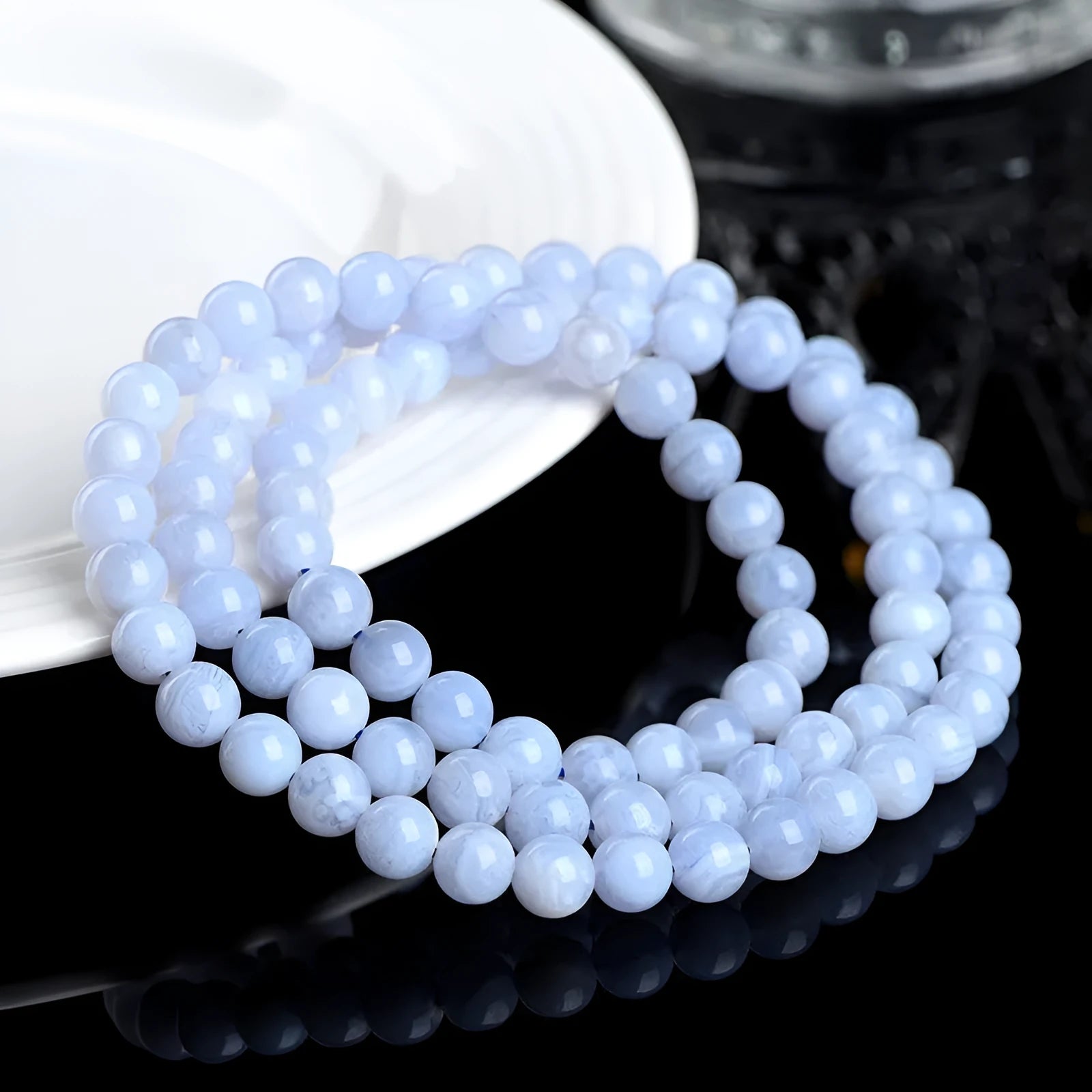 Blue agate bracelet with natural striped pattern and scattered bead design featuring Ruyi elements
