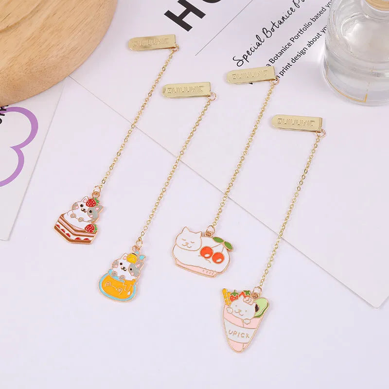 Metal cat pendant bookmark showing one of four cartoon designs: Strawberry Cake, Fruit Roll, Cherry Sleeping, or Yellow Fortune Bag cat.