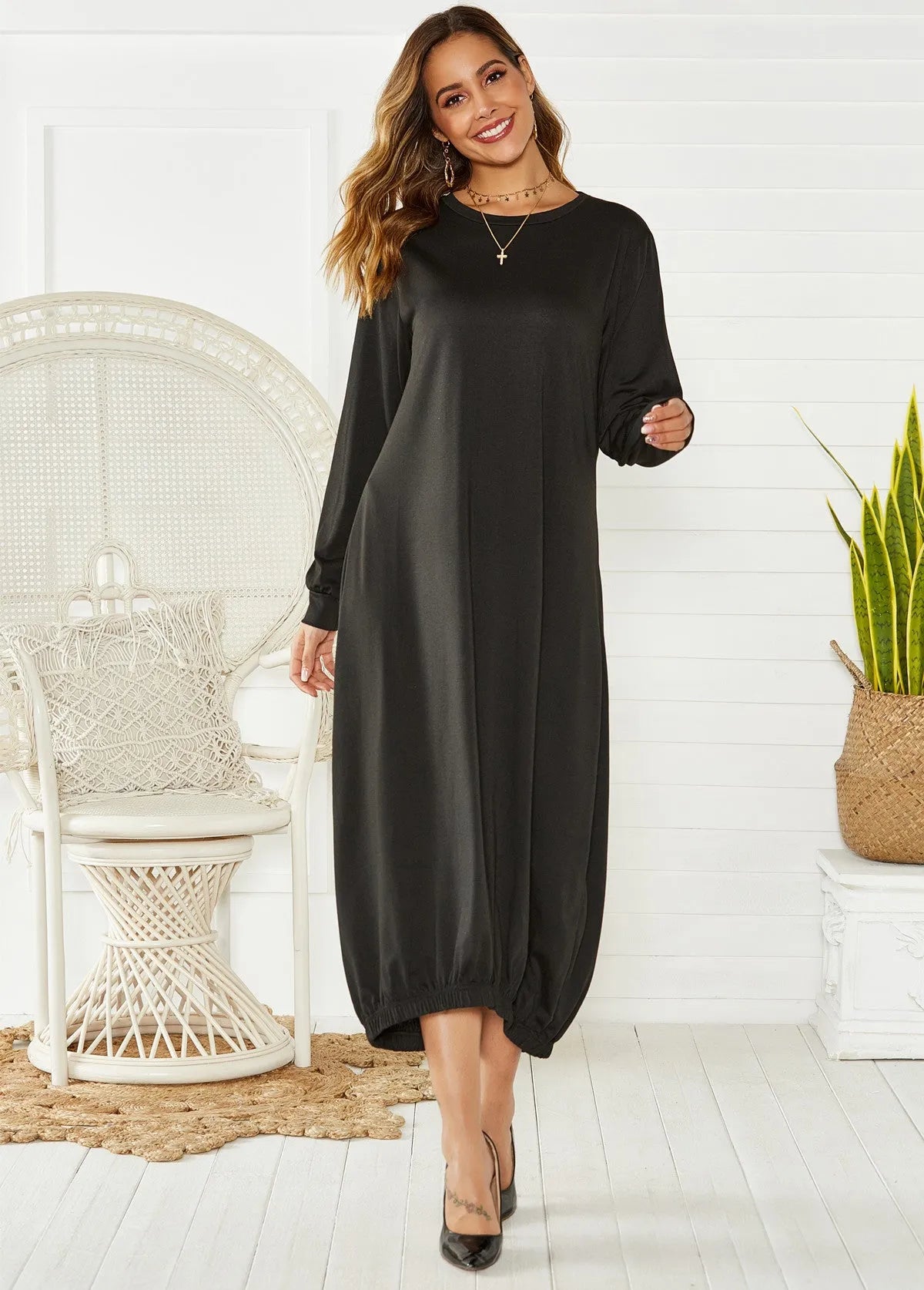 A loose black knitted lantern dress with a lace-up crew neck, showcasing a casual silhouette.