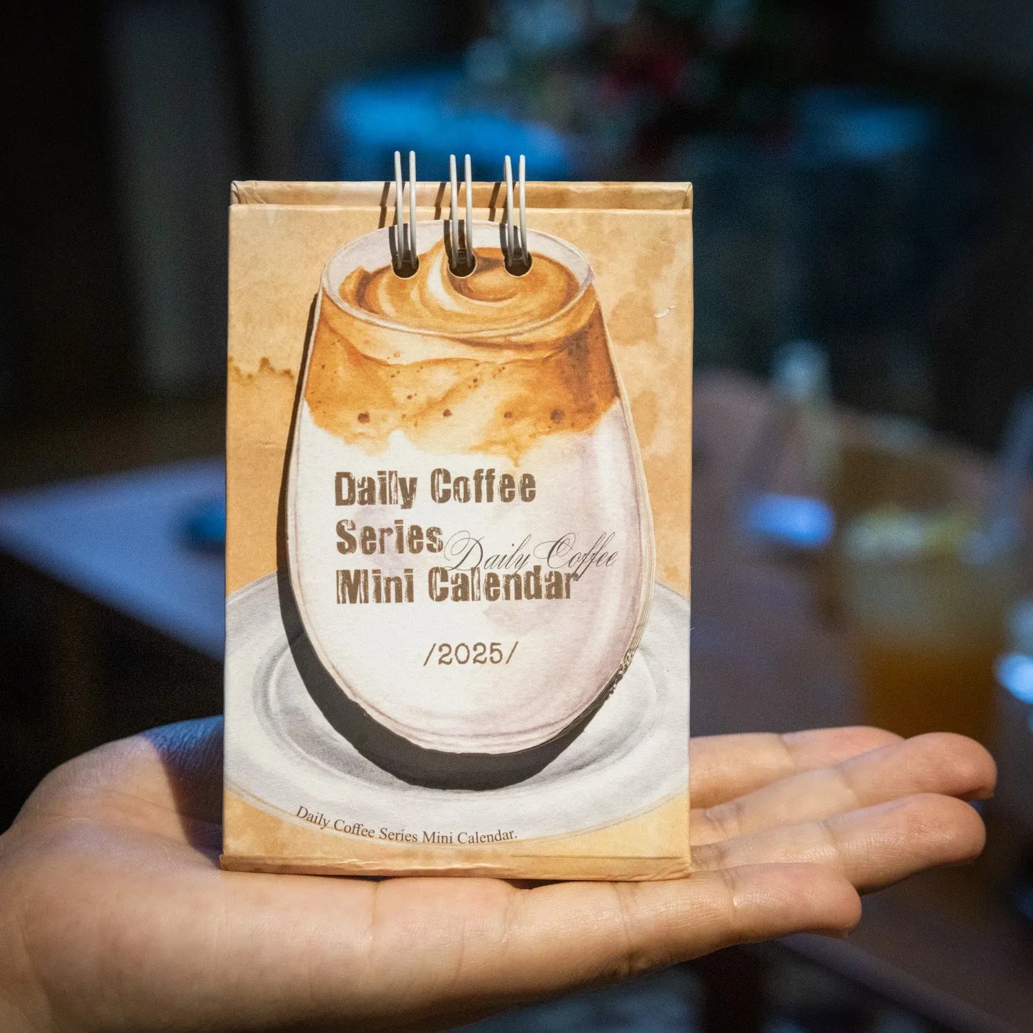 Mini 2025 desk calendar in a simple modern design on a wooden desk