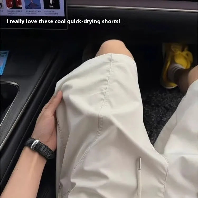 Men's beige quick-drying polyester sports shorts with elastic waistband, shown in a straight cut style.