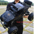 Black and silver remote control climbing cars with 2.4G wireless controller on a rough surface.
