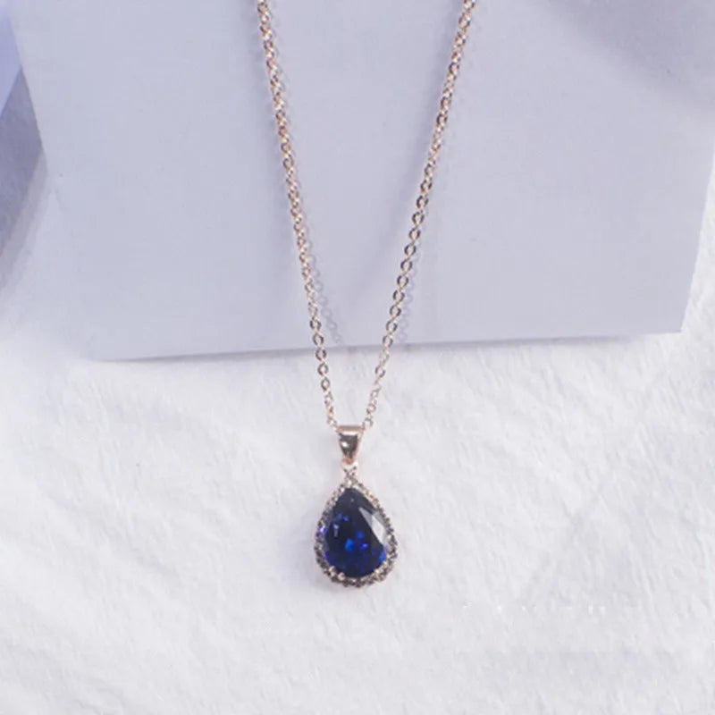 Pink water drop shaped rhinestone necklace with rose gold electroplated alloy pendant on white background