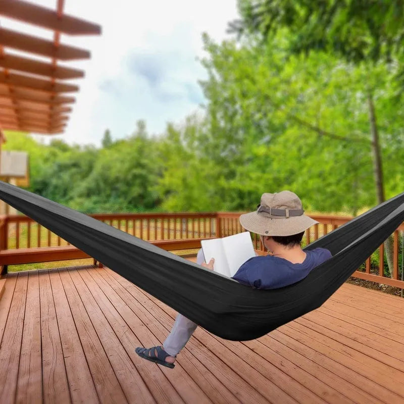 Double camping parachute hammock in 210T nylon black brown colour with tree straps and carabiners on outdoor setting