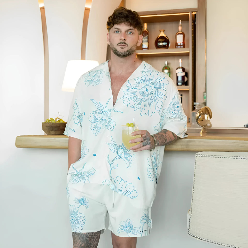 Man wearing a loose grey short sleeve cardigan top with a white floral print pattern.