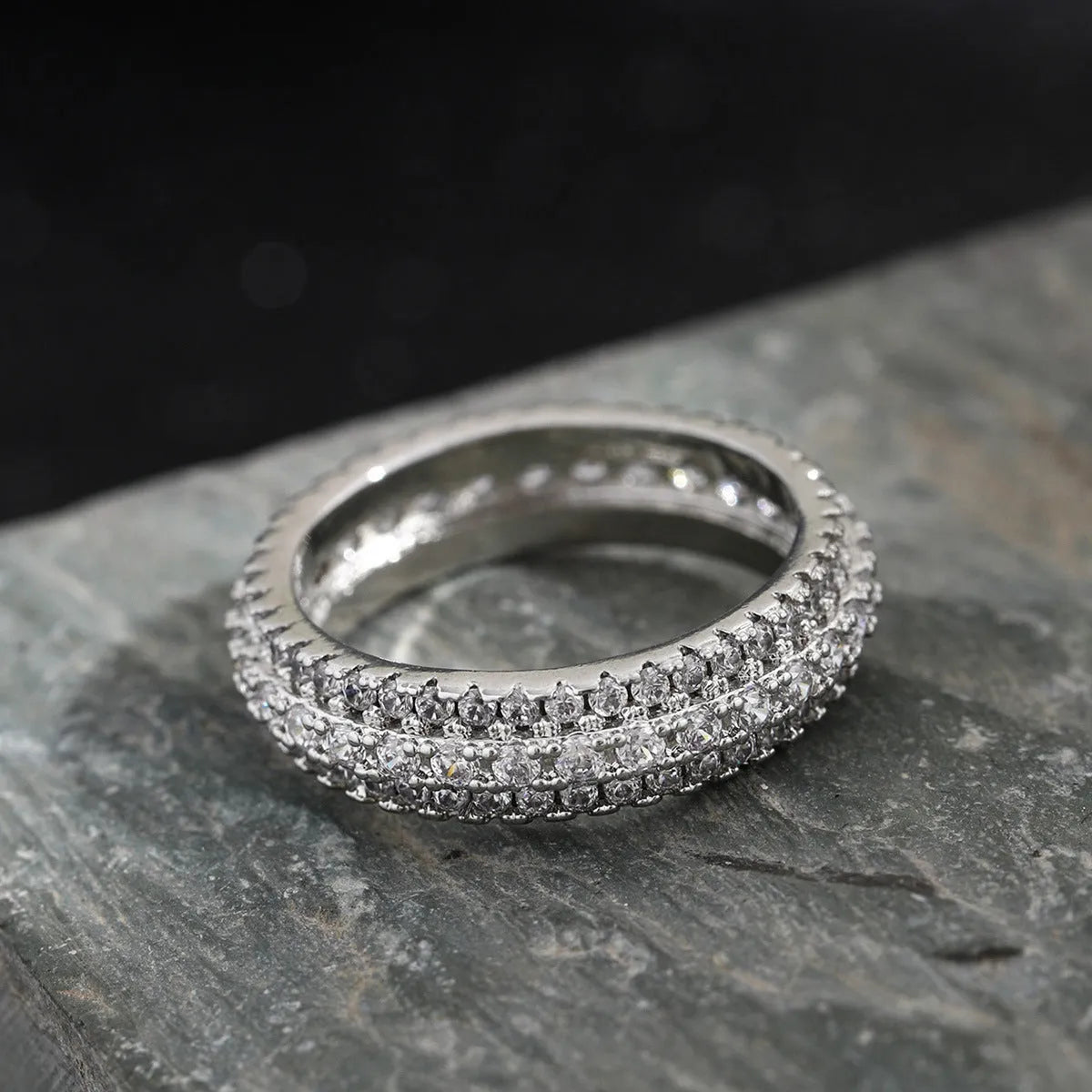 Geometric triangle design engagement ring with zircon stone inlay, shown in different metal plating finishes.
