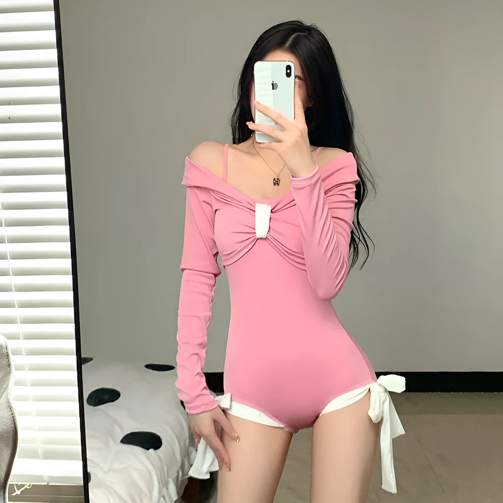 Women's long sleeve one-piece swimsuit in pink and black, made from polyester fabric.