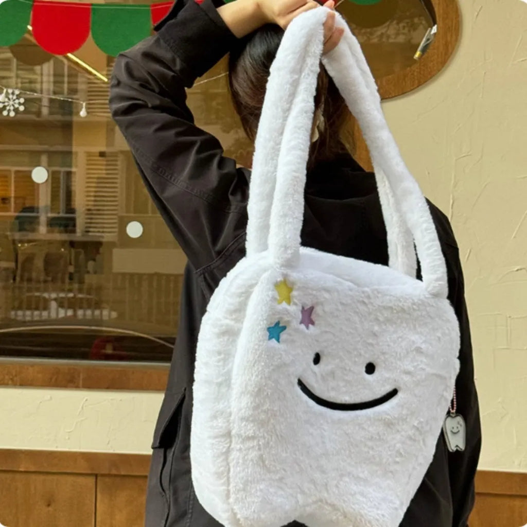 White shoulder tote bag with plush large tooth decorative detail and zip closure