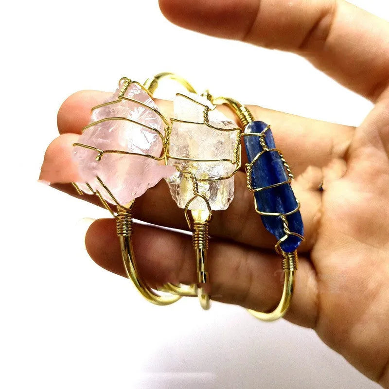 Geometric natural crystal bracelet with gold metal winding on a wrist.