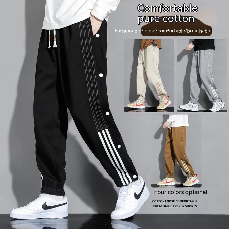 Man wearing loose grey cotton blend sweatpants with ankle ties and a drawstring waist.