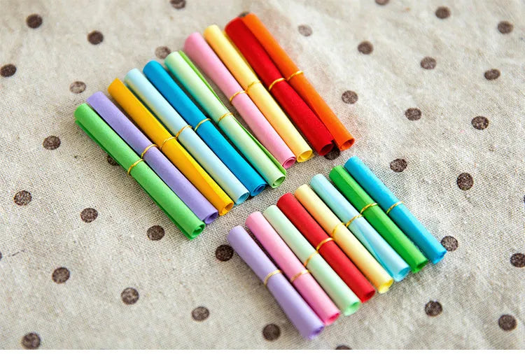 Assorted colourful scroll-style paper notes with metal eyelets in four different sizes.