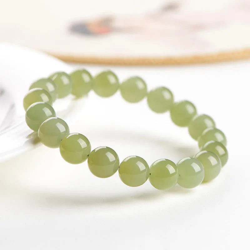 Polished Hetian jade beaded bracelet in ice-like clear water colour on a wrist.