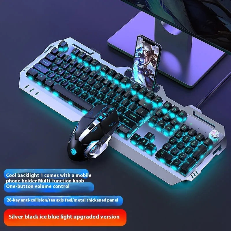 Aluminium gaming keyboard with volume knob, shown in metal grey with RGB lighting alongside optional macro mouse and headset.