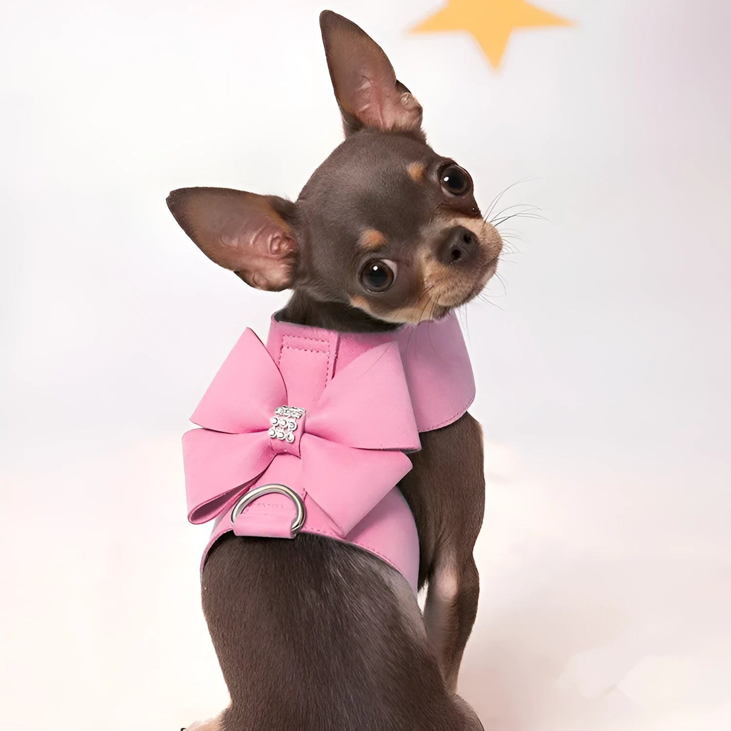 A pink microfiber dog chest strap with a large decorative bowknot, shown alongside blue and orange colour options.