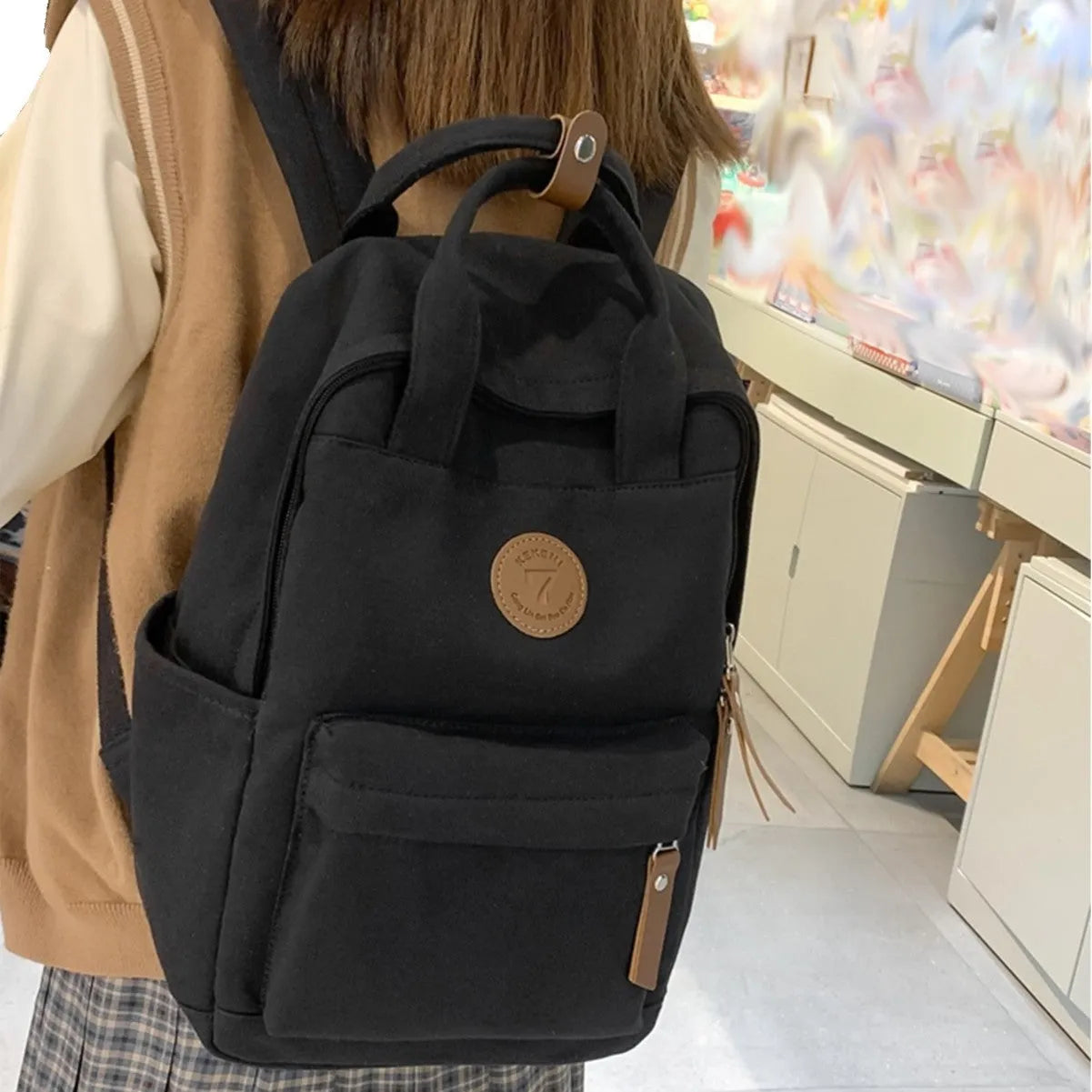 Solid black retro Oxford cloth backpack with curved shoulder straps on a neutral background.