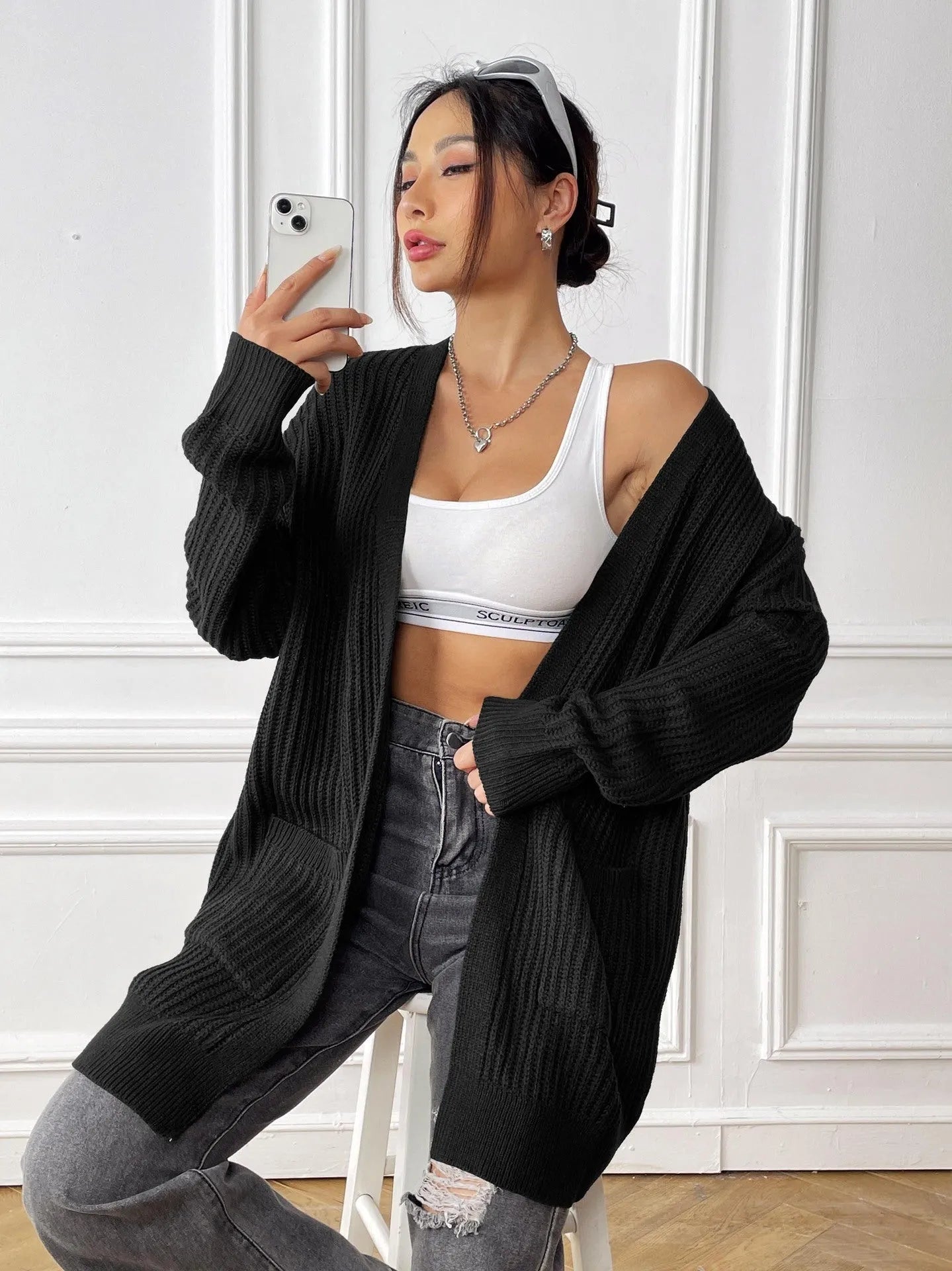 Women's dark green two-pocket acrylic cardigan sweater with loose fit and long sleeves