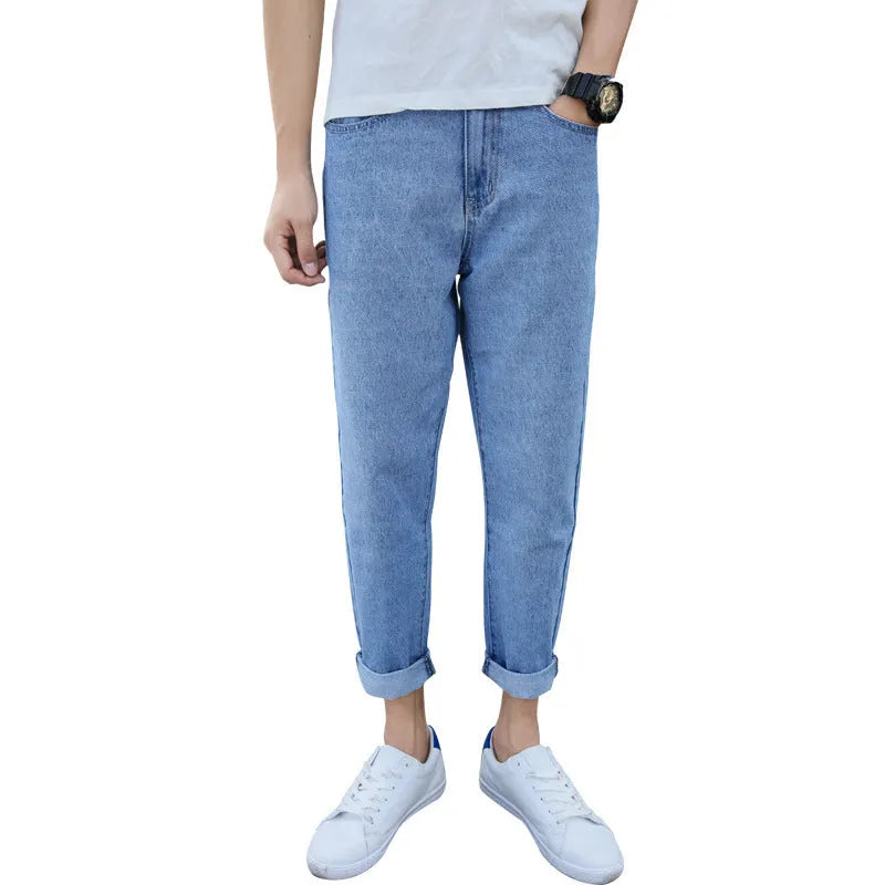A pair of men's loose straight-leg jeans in a blue colour on a plain background.