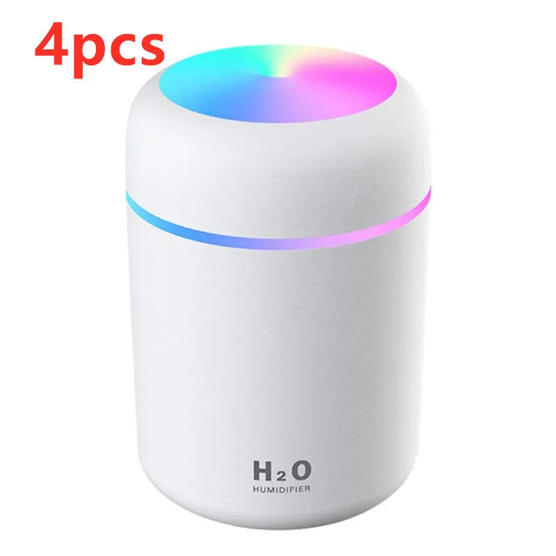 Pink USB mini humidifier with LED lights and water tank on desk