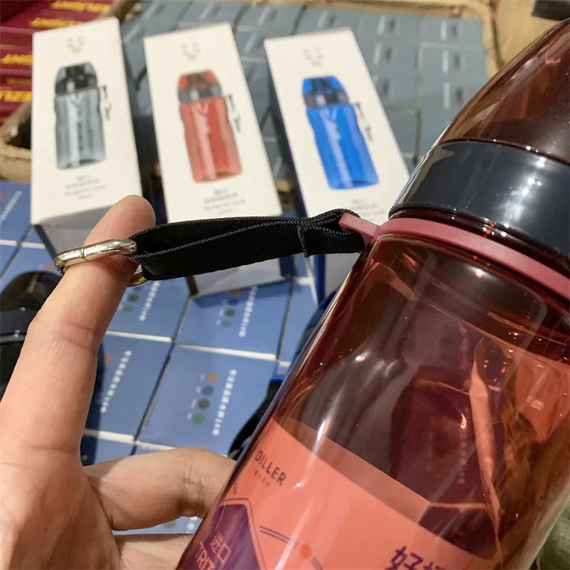 Blue portable sports water cup with a separate compartment for tea leaves on a wooden table.