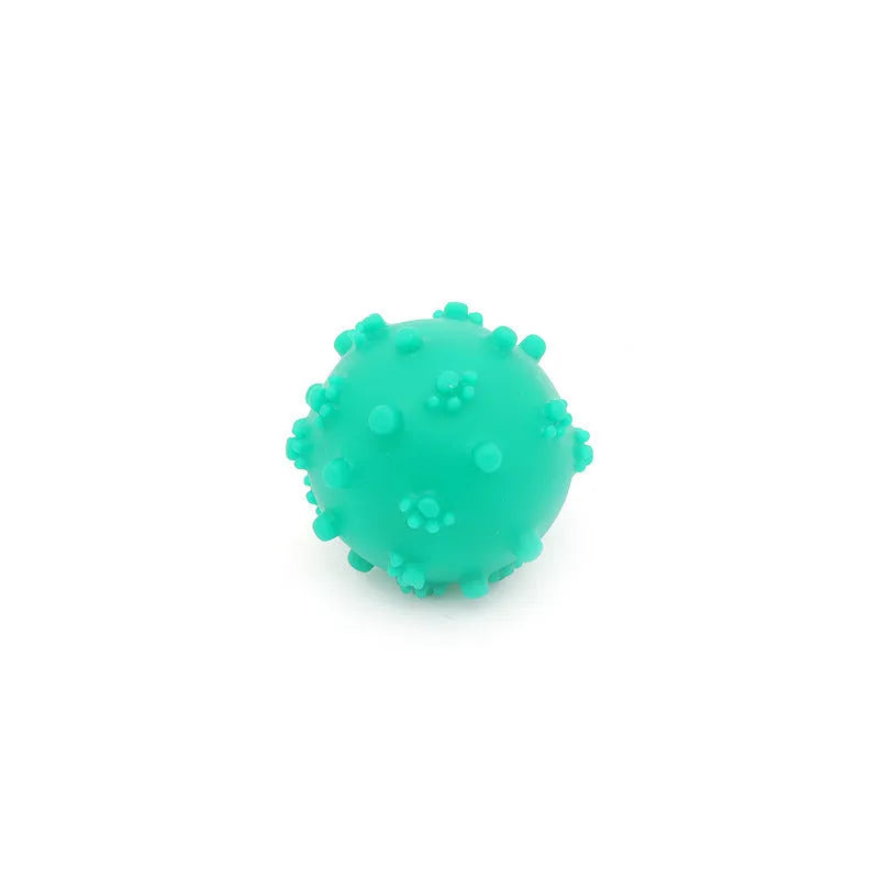 Bright blue, green, pink, and yellow spiked dog toy balls with paw print dimples on a white background.