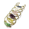 Geometric natural crystal bracelet with gold metal winding on a wrist.