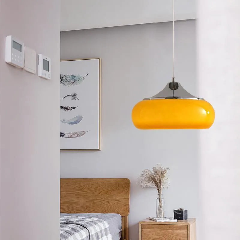 Three-headed Bauhaus pendant light with milky white glass egg tart shades hanging from a ceiling.