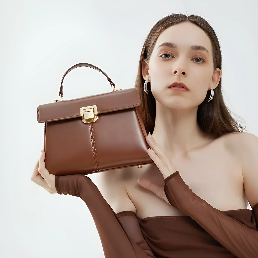 Black genuine vachette leather women's shoulder bag with clasp closure, showing square shape and adjustable strap.