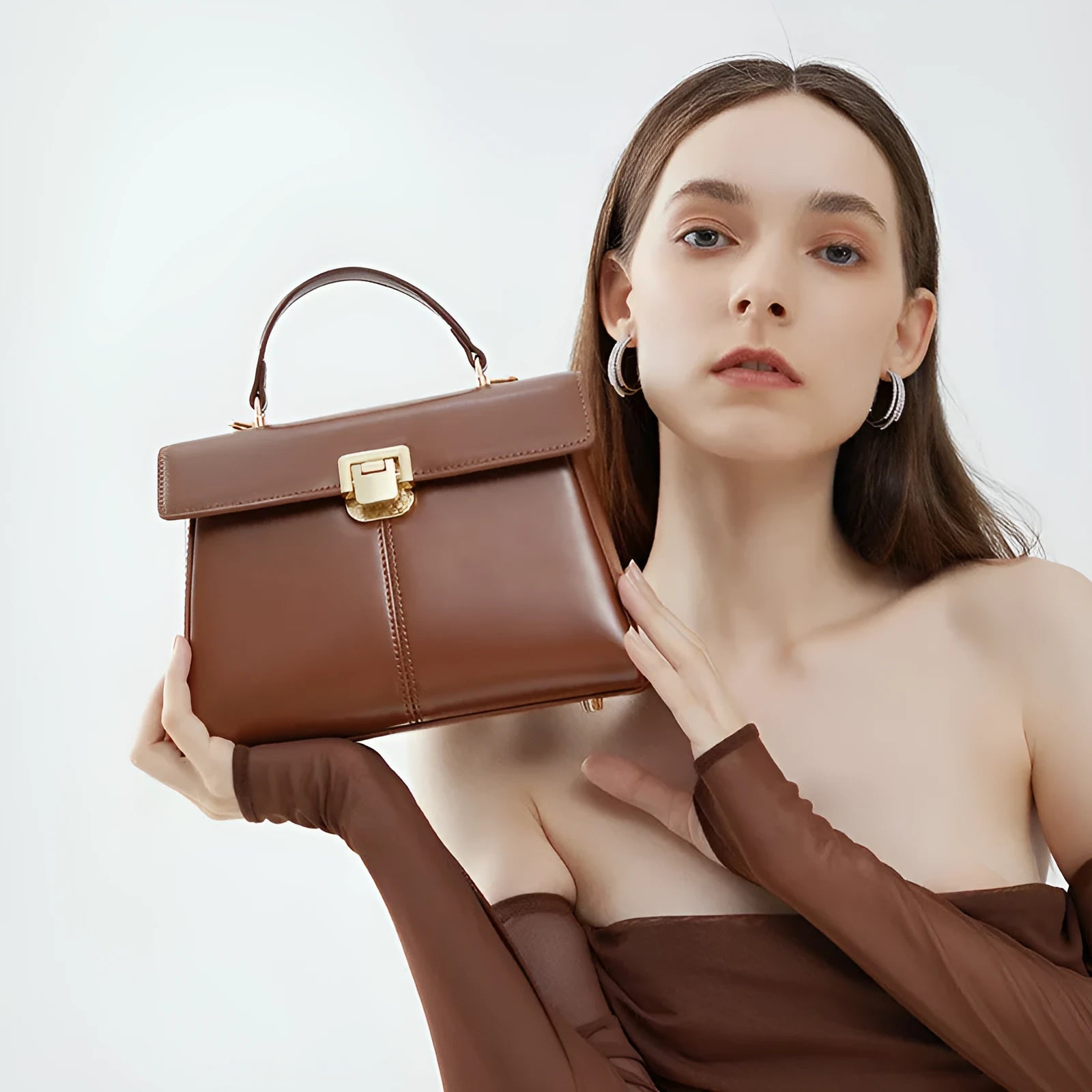 Black genuine vachette leather women's shoulder bag with clasp closure, showing square shape and adjustable strap.