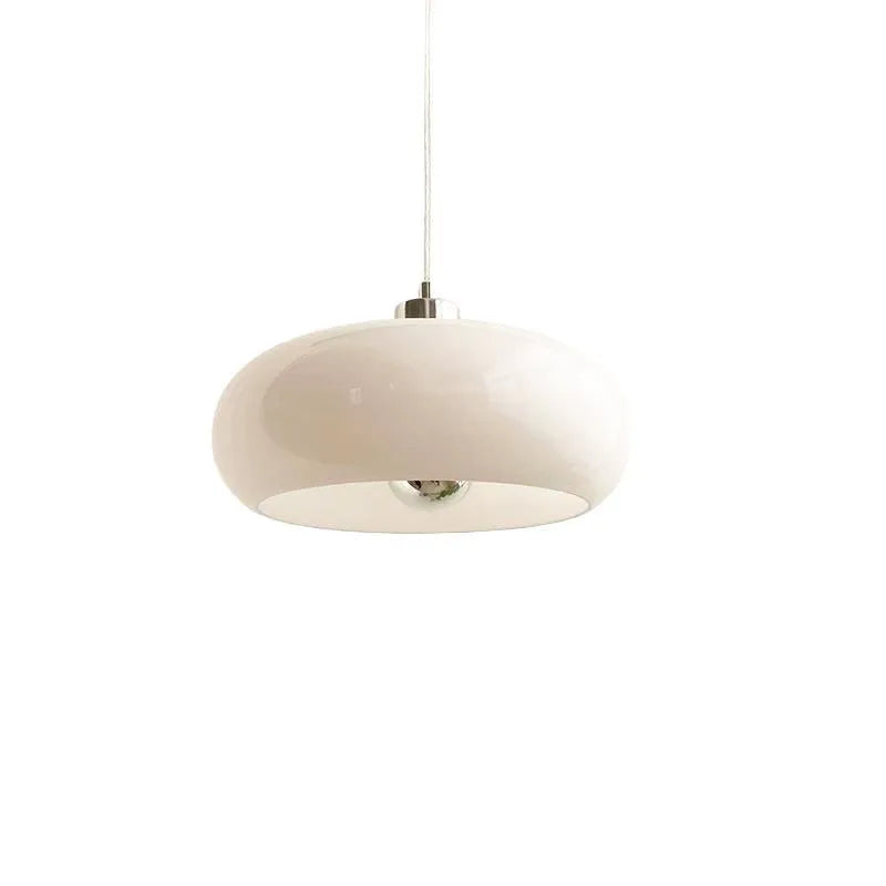Three-headed Bauhaus pendant light with milky white glass egg tart shades hanging from a ceiling.