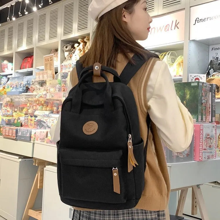 Solid black retro Oxford cloth backpack with curved shoulder straps on a neutral background.