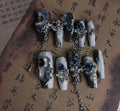 Women's ornate rose floral pattern manicure nails in heavy industry blue colour on a plastic armour suit.