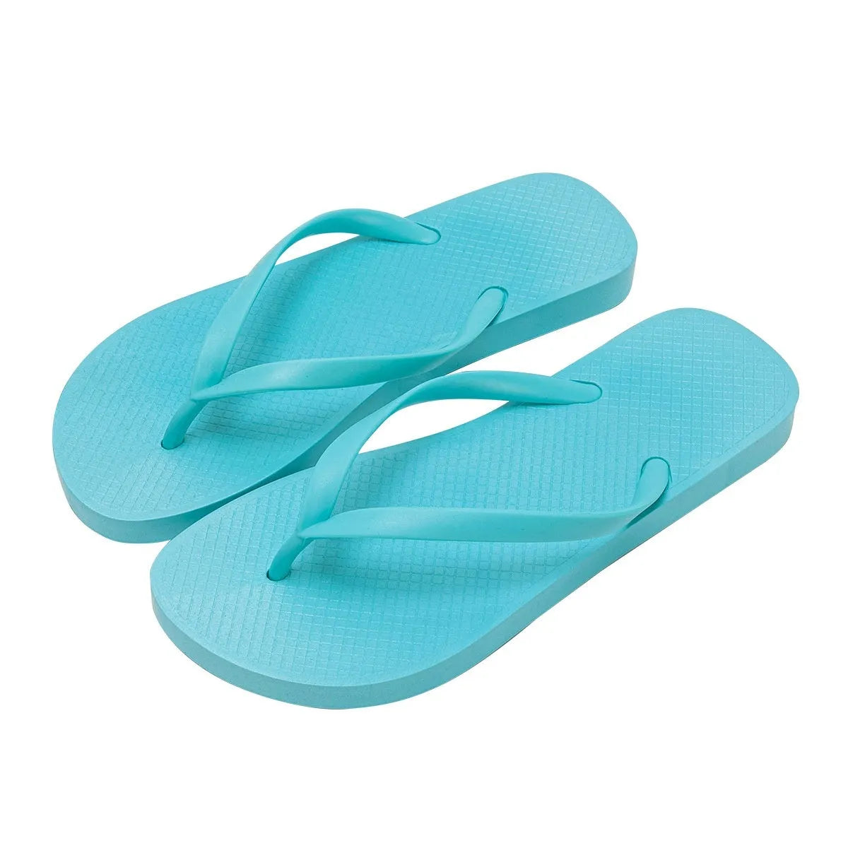 Orange foldable beach slippers with a hollow-out plastic upper and non-slip PVC sole on a sandy background.