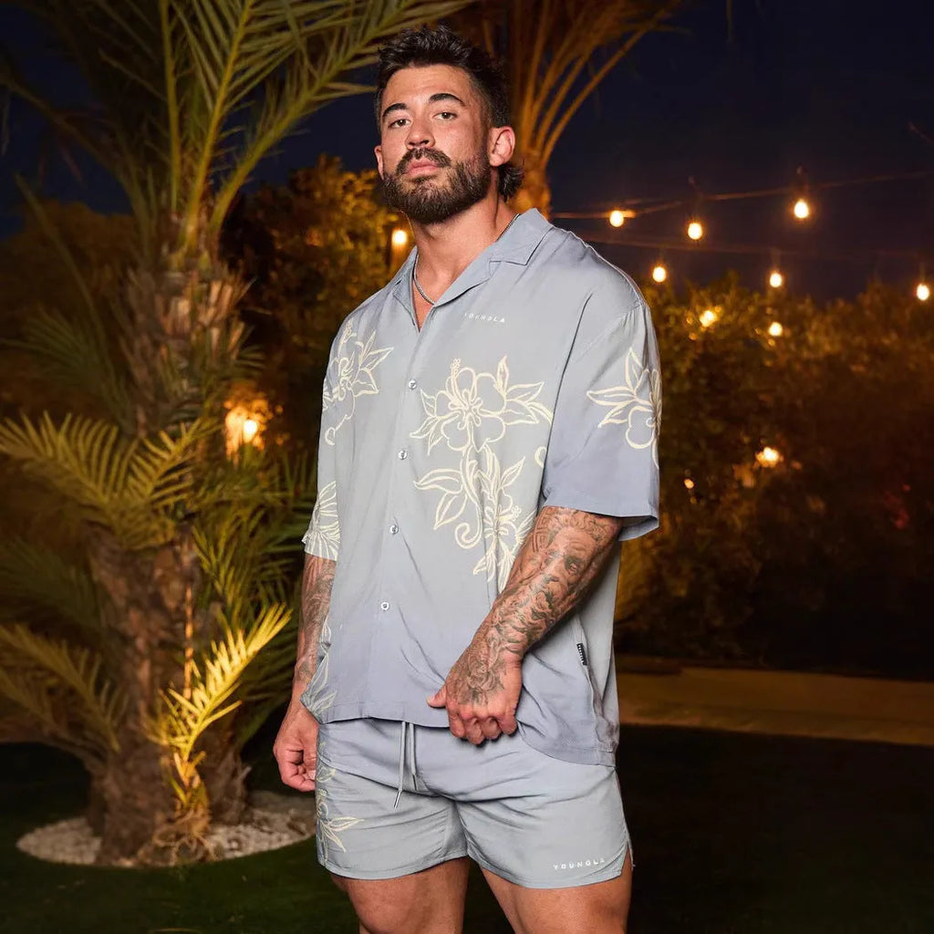 Man wearing a loose grey short sleeve cardigan top with a white floral print pattern.