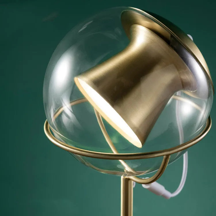Clear glass desk lamp with dimmable LED light and touch switch on base.