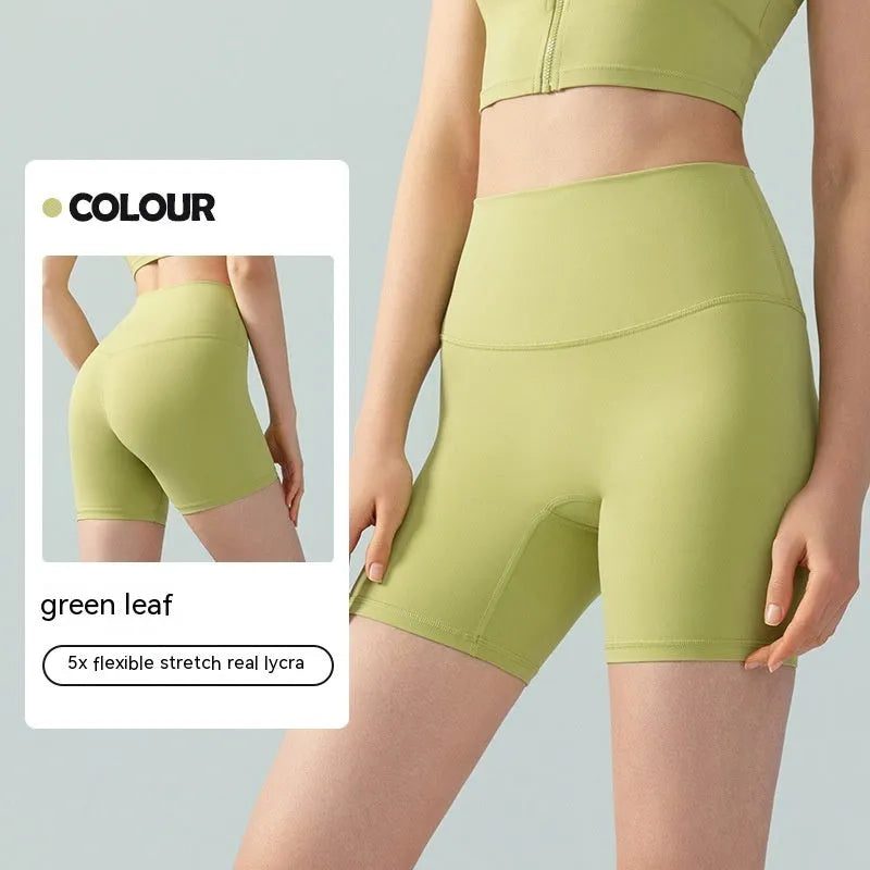 Women's high waist Lycra yoga shorts in leaf green, shown in a yoga pose.