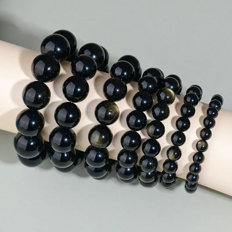 Hand-woven obsidian bracelet with round beads and engraved birth year detail for couples