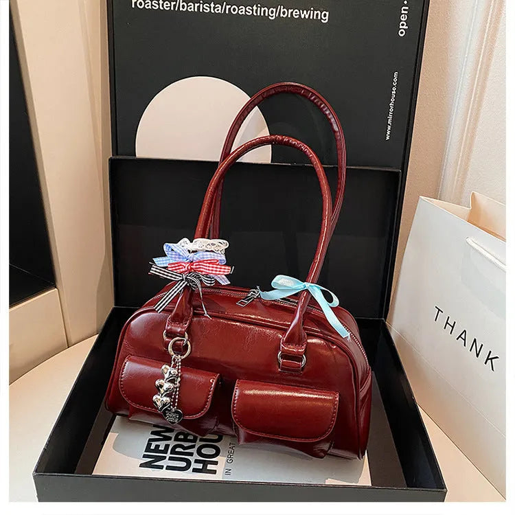 Retro brown PU leather women's pillow handbag with a flap and double shoulder strap on a neutral background.