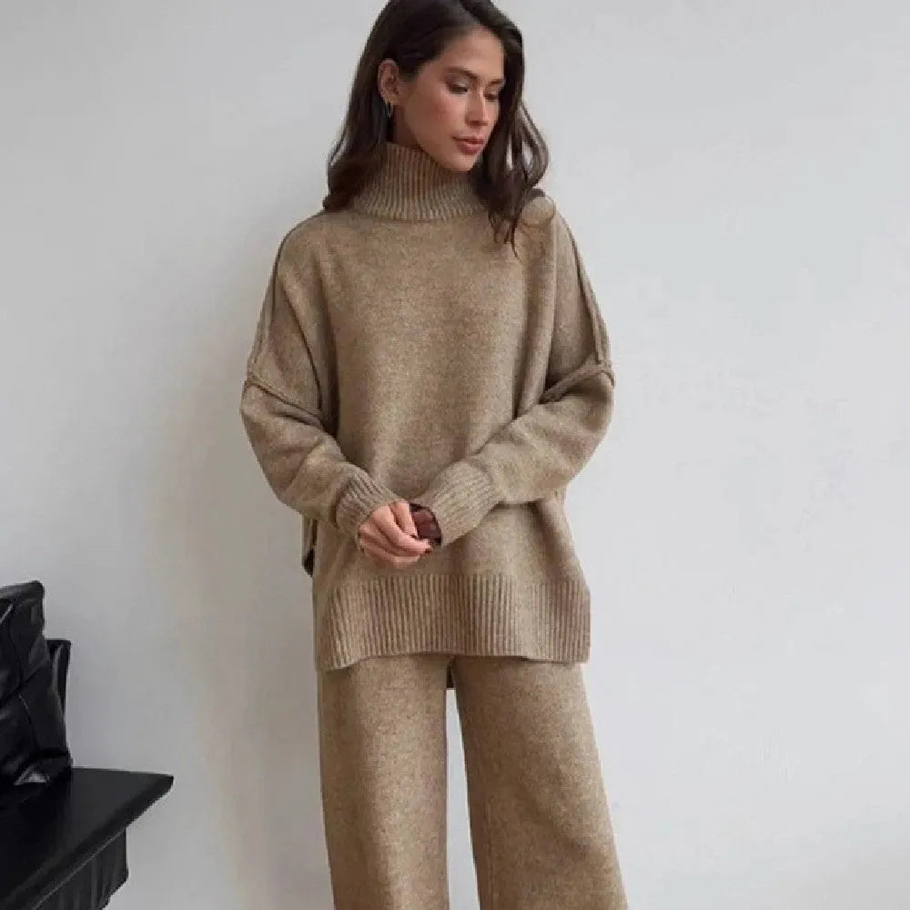 Women's dark grey knit co-ord suit with side-slit sweater and matching trousers laid flat.