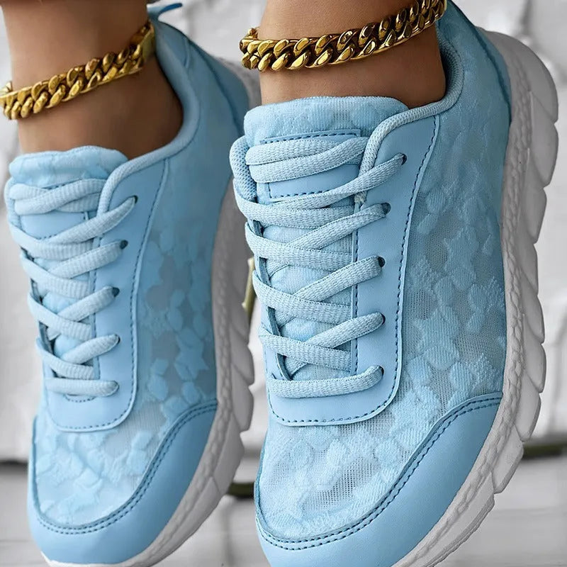 Women's white canvas running shoes with soft sole and flat heel on a plain background.