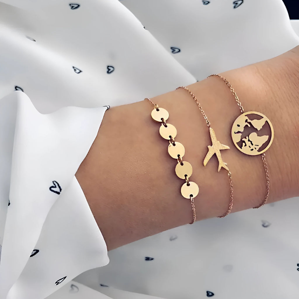 Three silver-tone alloy bracelets with heart-shaped charms featuring aircraft and map designs.