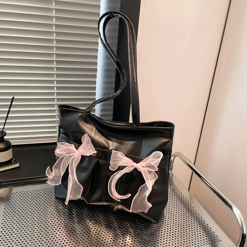 Black and pink college style bow tote bag with double straps and a front view.
