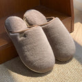 Solid colour PVC winter plush house slippers with car stitching detail on a non-slip sole.