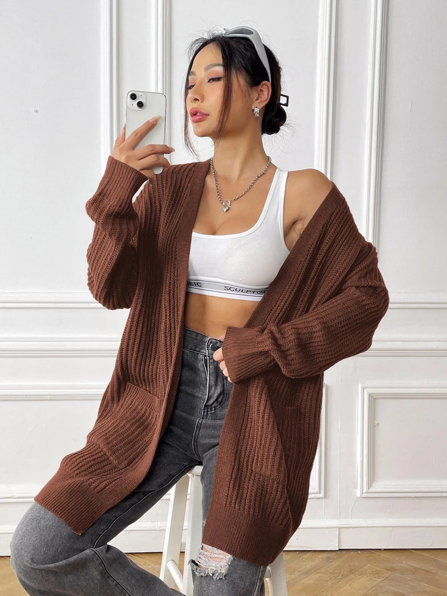 Women's dark green two-pocket acrylic cardigan sweater with loose fit and long sleeves