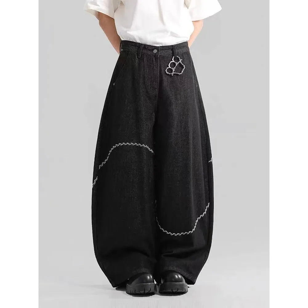 Men's black straight-leg denim trousers with a zip fly on a mid waist, shown in a casual street style.