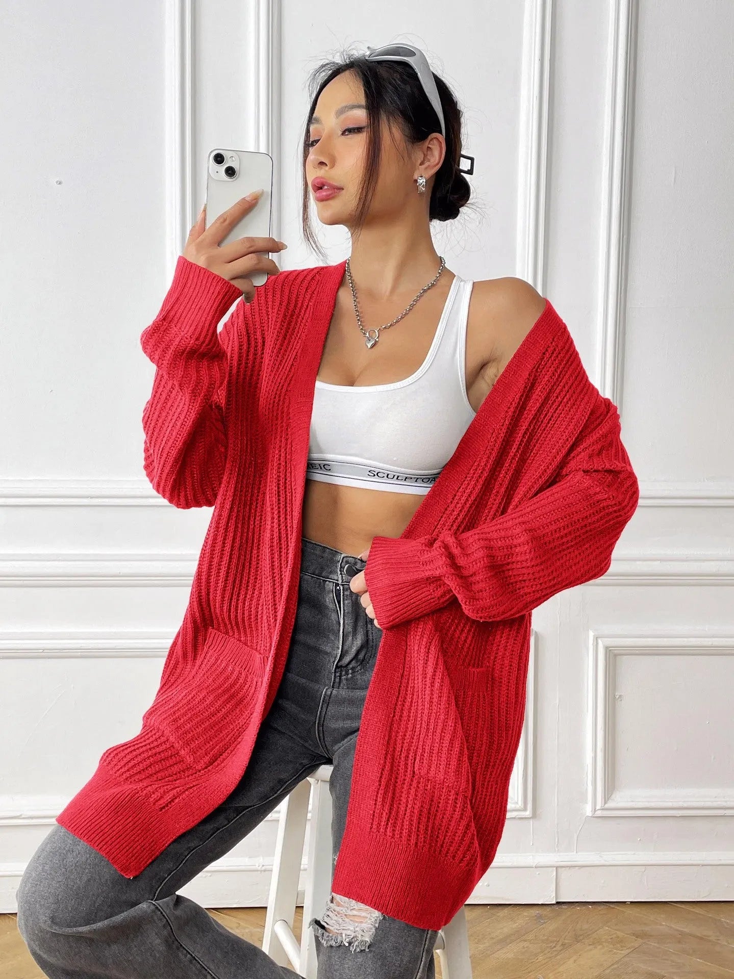 Women's dark green two-pocket acrylic cardigan sweater with loose fit and long sleeves