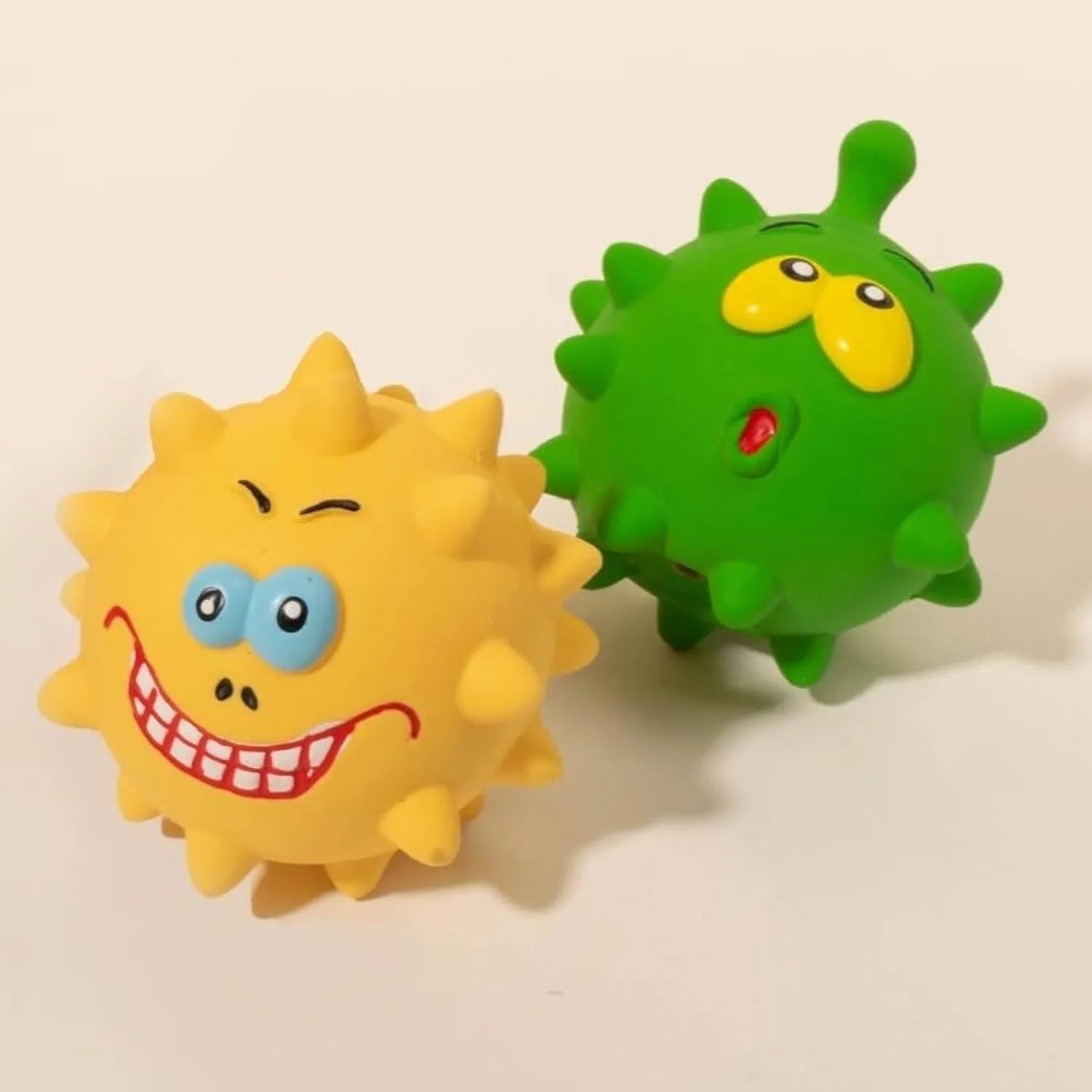 Four coloured squeaky dog balls with cute faces, made from natural latex rubber for safe chewing
