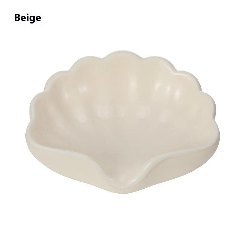White or pink shell-shaped plastic soap dish for bathroom countertop.